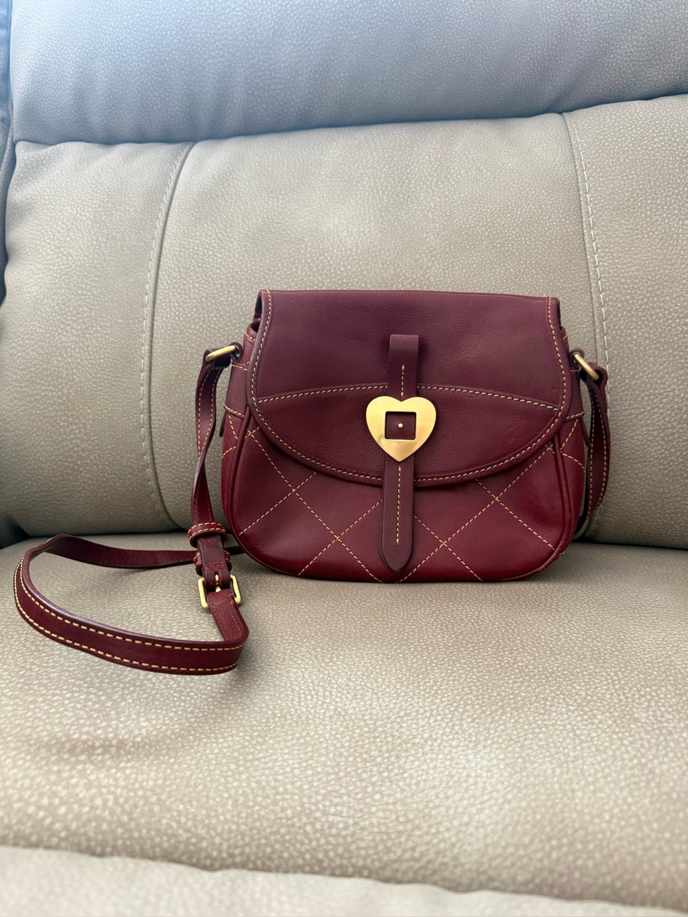 Used Dooney and Bourke heart buckle leather flap saddle bag